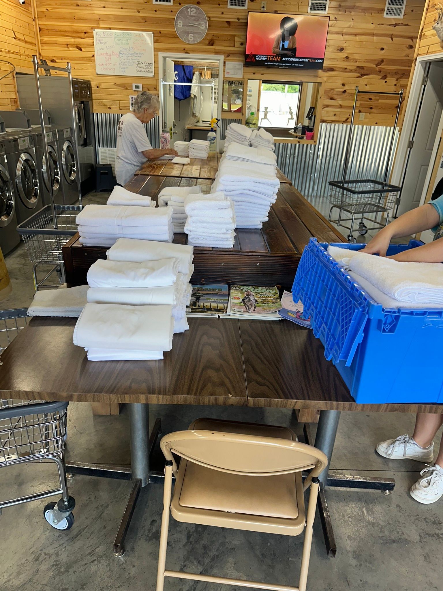 Volunteers stacking white foam boxes on tables in a rustic indoor workspace