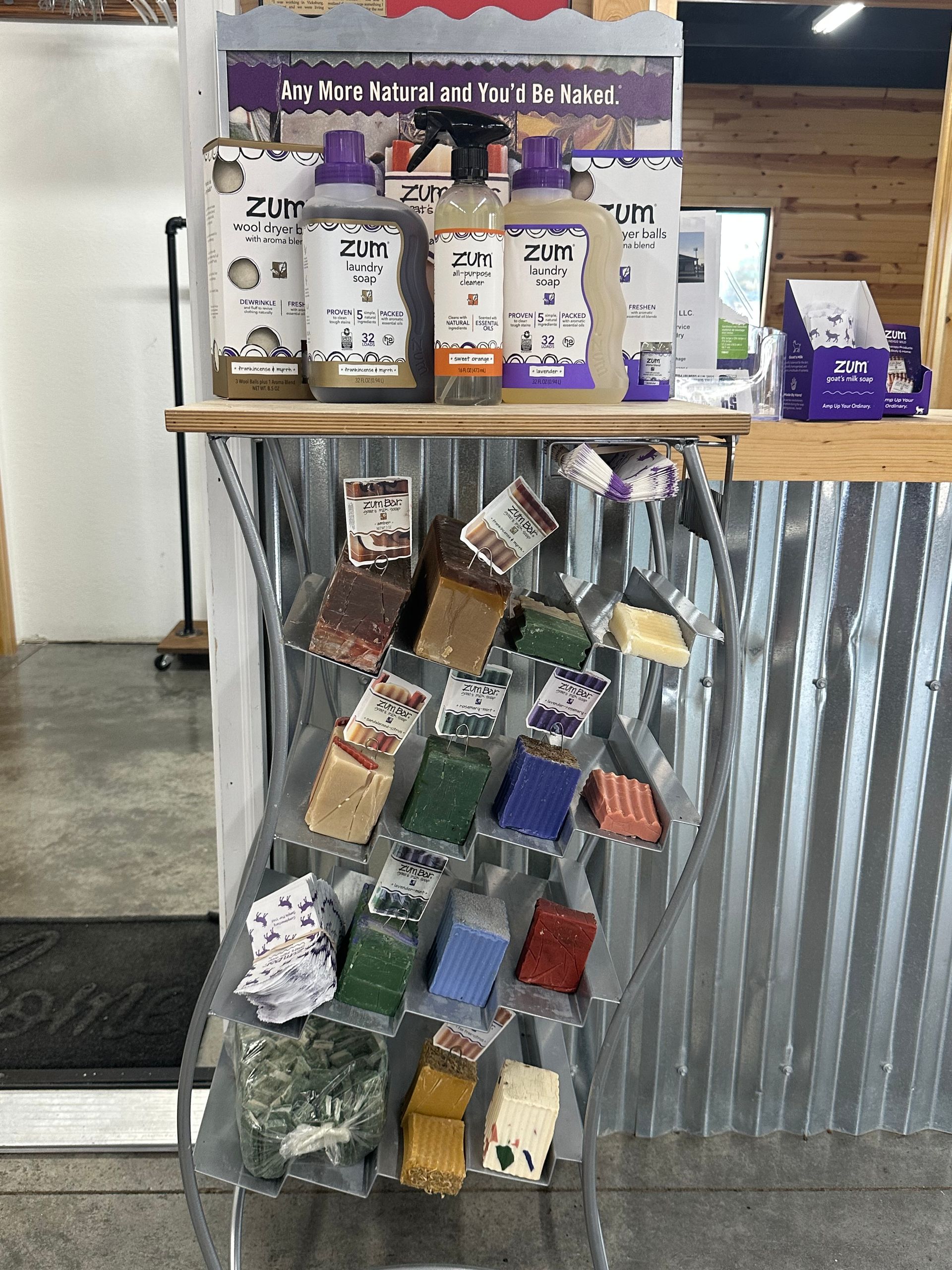 Display rack with bottled drinks and hanging snack pouches in a rustic shop setting