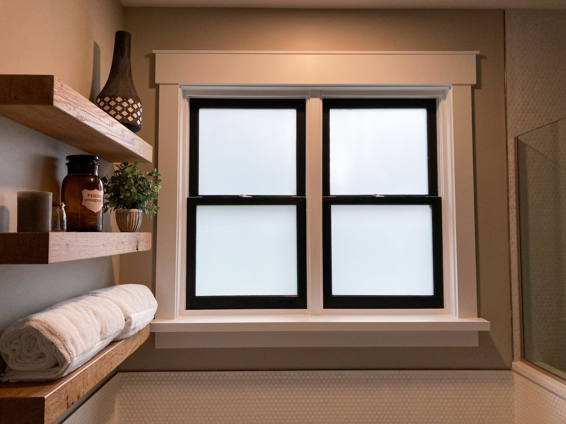 A bathroom with two shelves and a window.