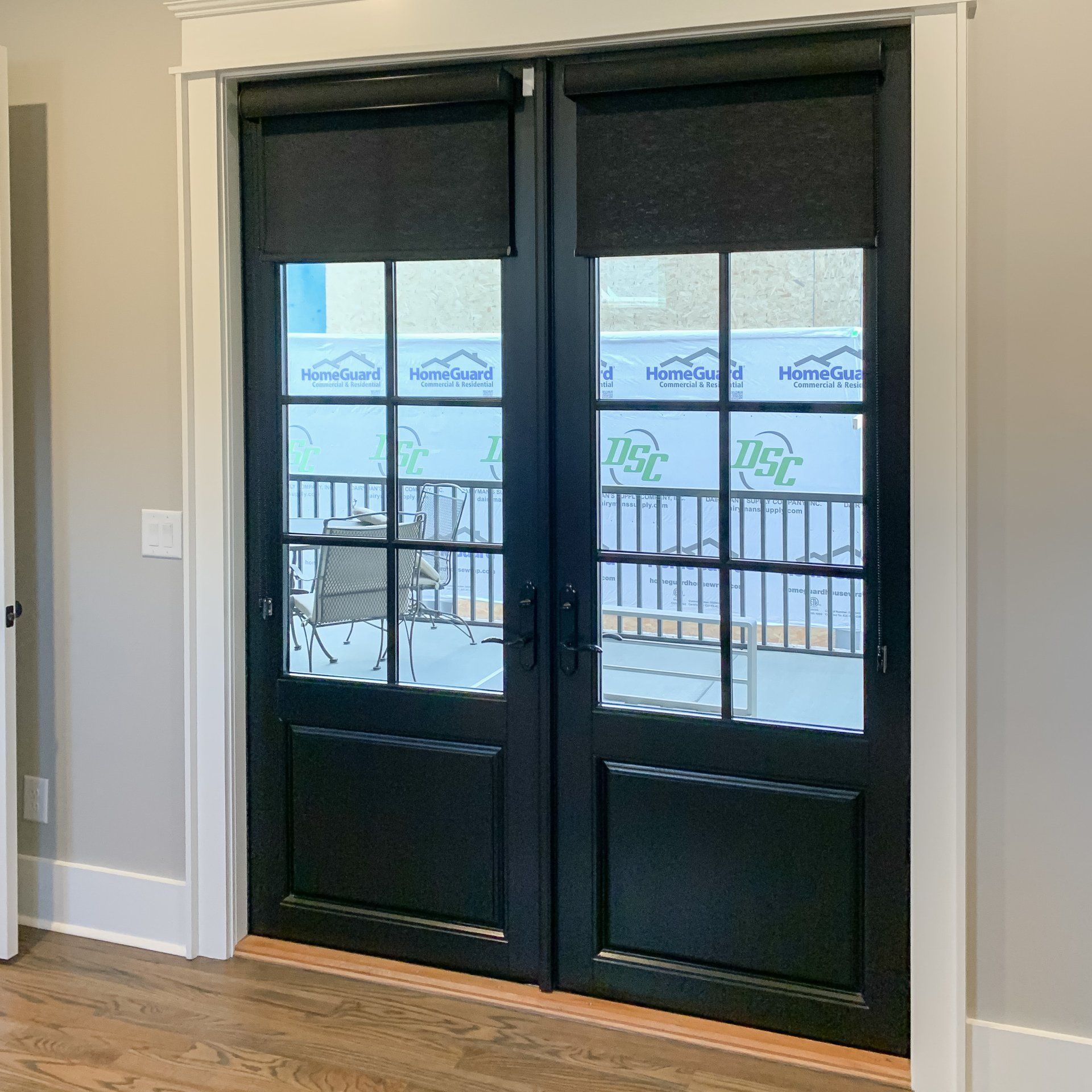 A pair of black sliding glass doors with blinds in a room.