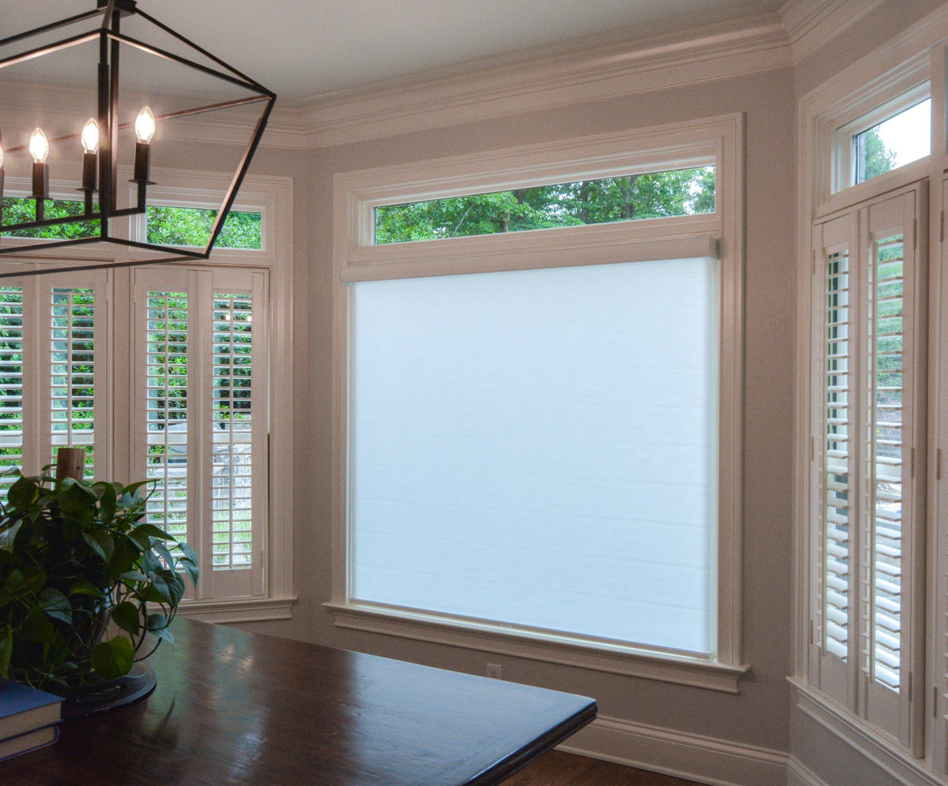 A living room with a large window and shutters