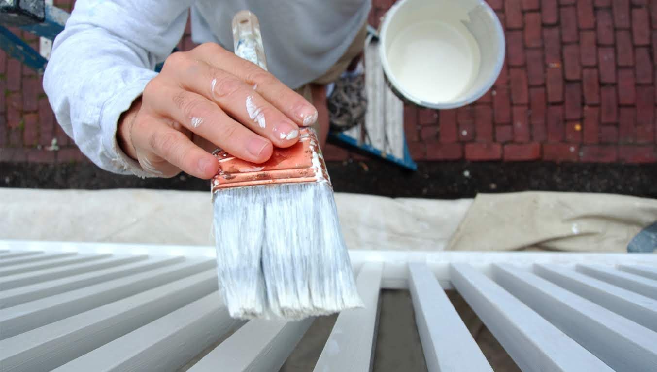 a person is painting a light blue wall with a white paint roller