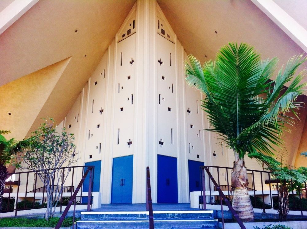 Los Altos United Methodist Church entrance with tall white facade, blue doors, and palm trees under a slanted roof