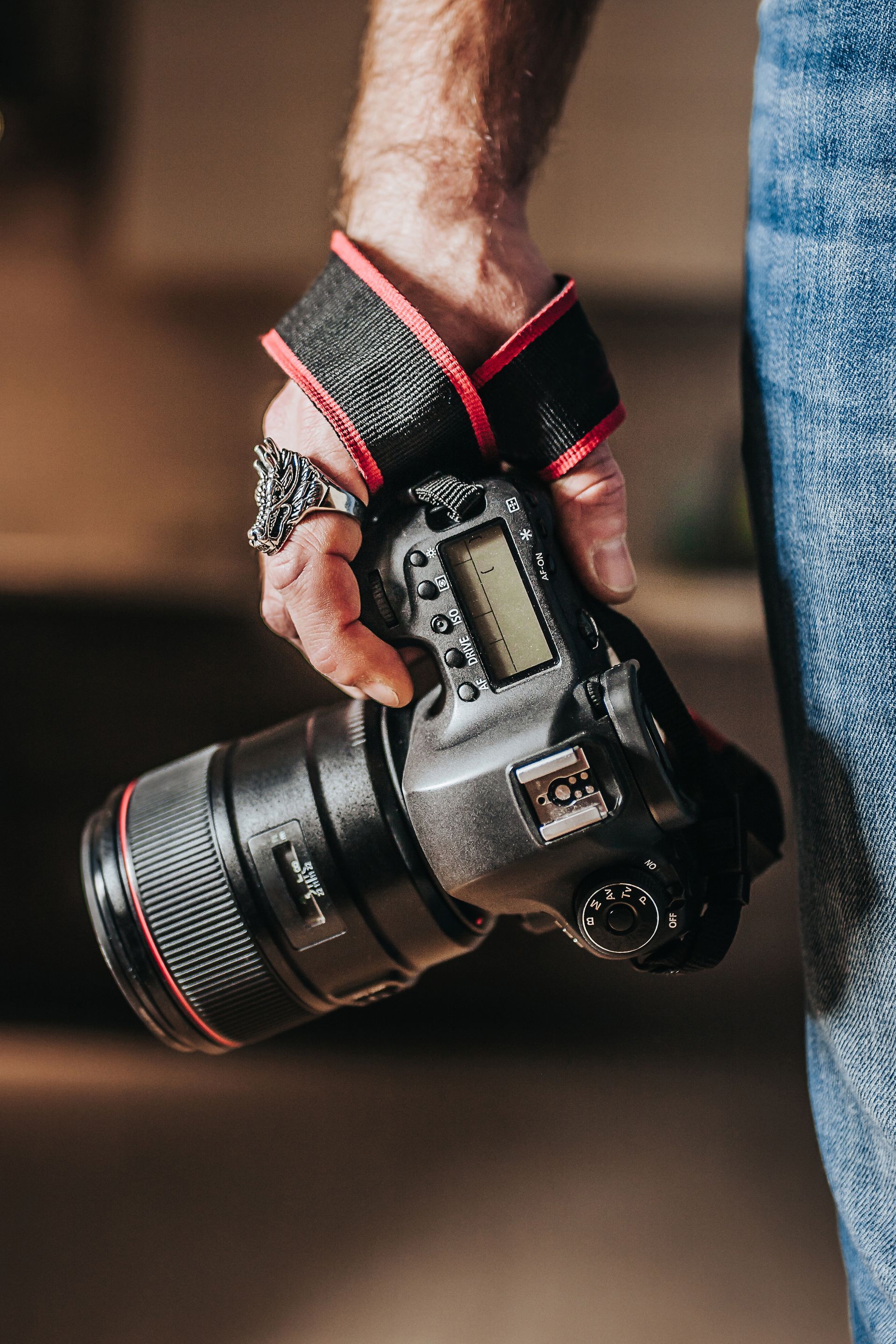 Hand holding a black camera.