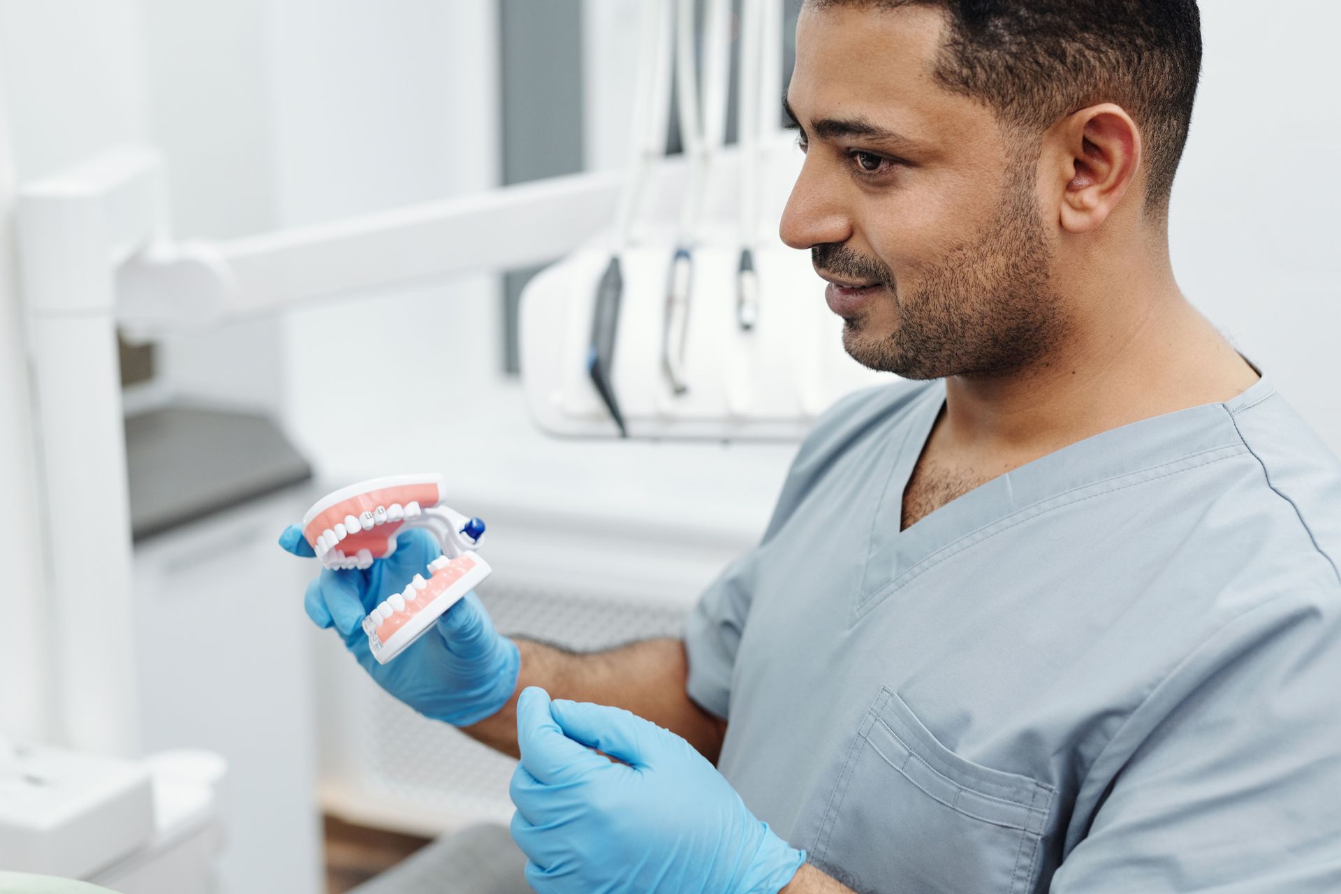 Denturist examining dentures in a clinic room