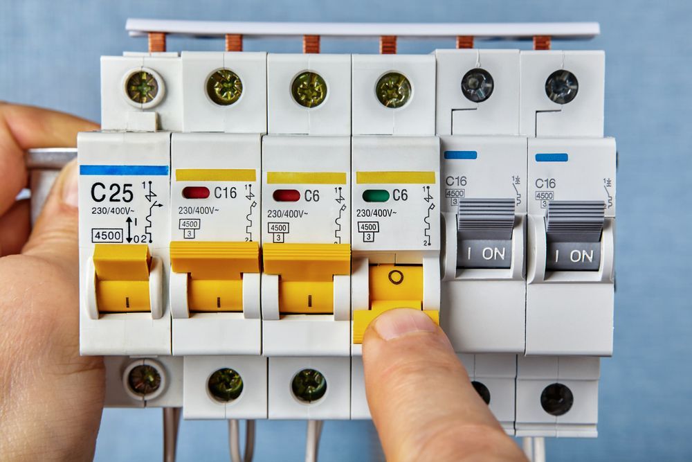 A Person Is Holding A Circuit Breaker In Their Hand — All Star Electrical Services in Thirroul, NSW