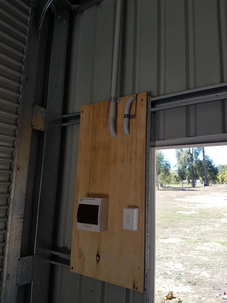 A Wooden Board With A Box On It Is Attached To A Metal Wall — All Star Electrical Services in Austinmer, NSW
