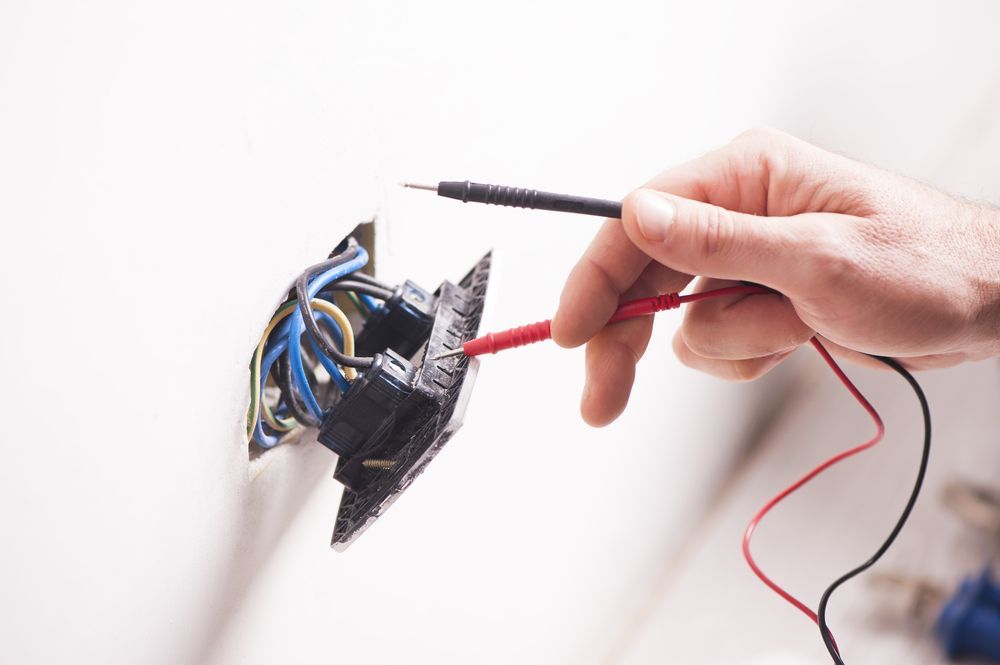 A Person Is Installing a Light Switch on A Wall — All Star Electrical Services in Horsley, NSW