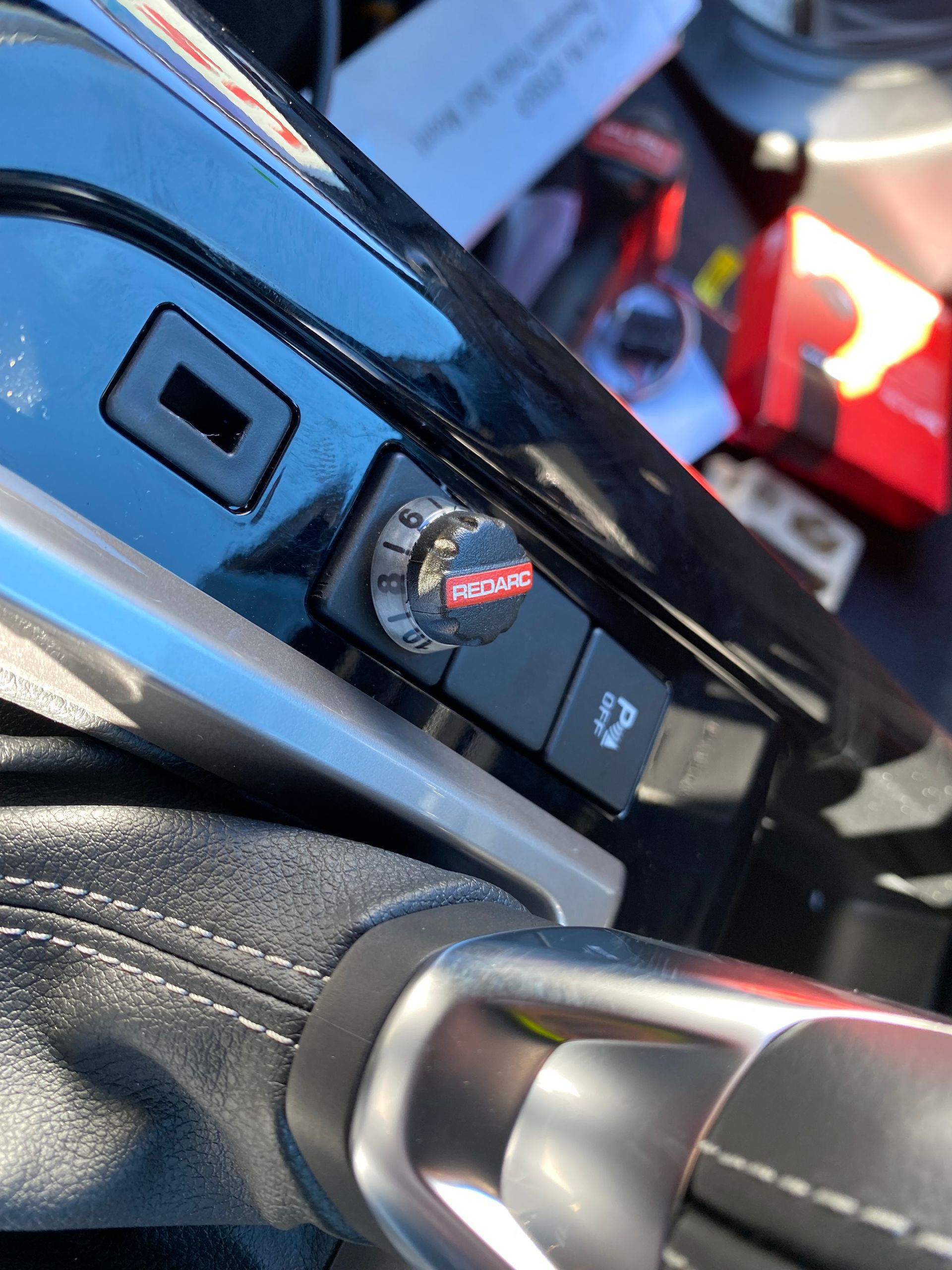 Black car console with a dial that says