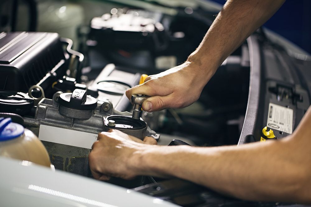 A Man Is Working On The Engine Of A Car — Josh's Diesel Services in Boyne Island, QLD