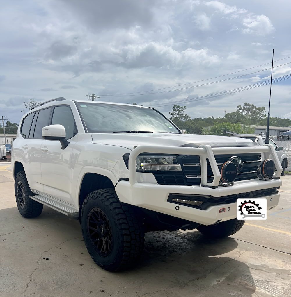 A White Suv Is Parked In A Parking Lot — Josh's Diesel Services in Calliope, QLD