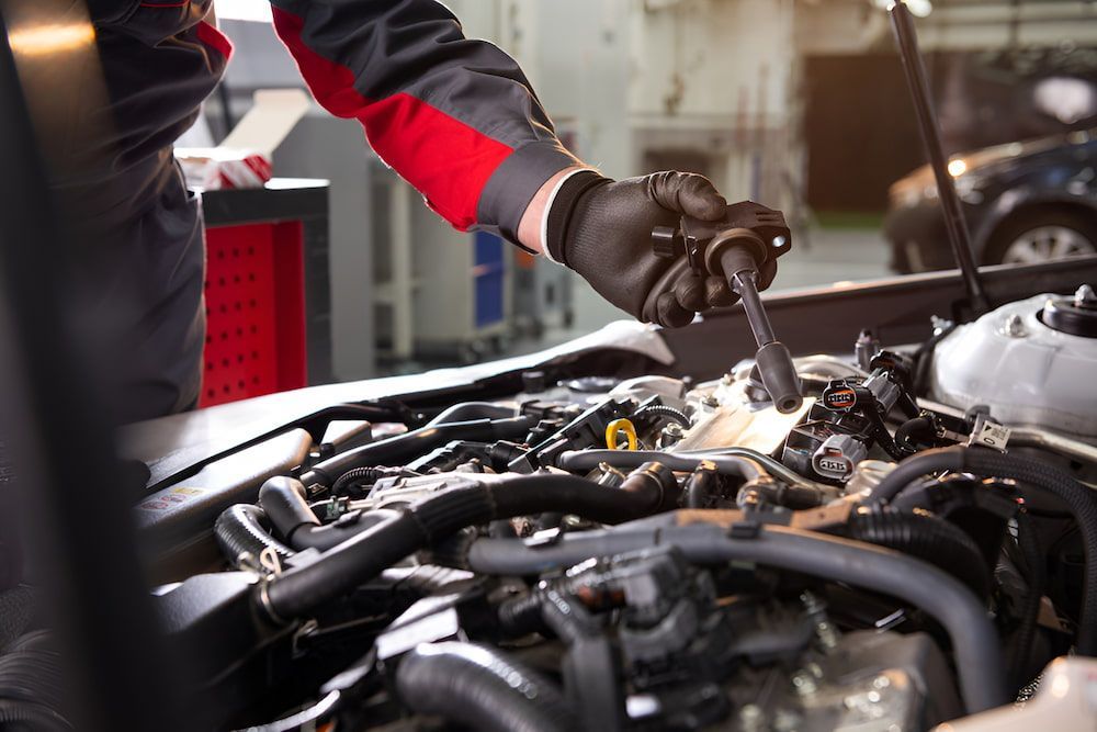 A Mechanic Is Working On The Engine Of A Car In A Garage — Josh's Diesel Services in Boyne Island, QLD