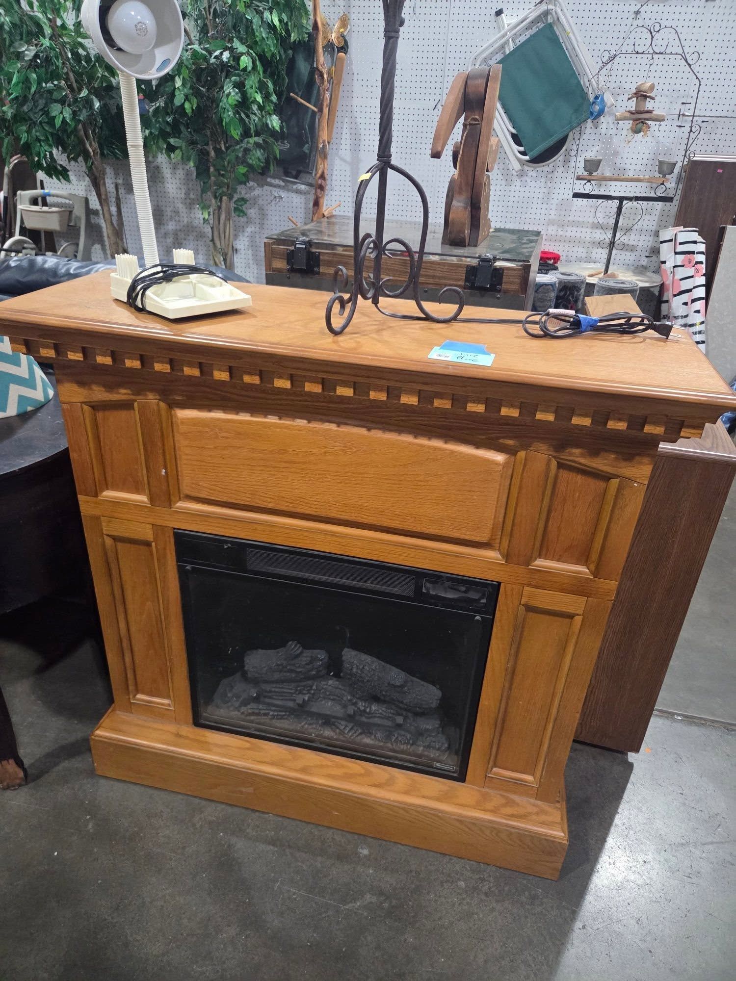 Wooden fireplace mantel with glass front, set in a workshop or showroom