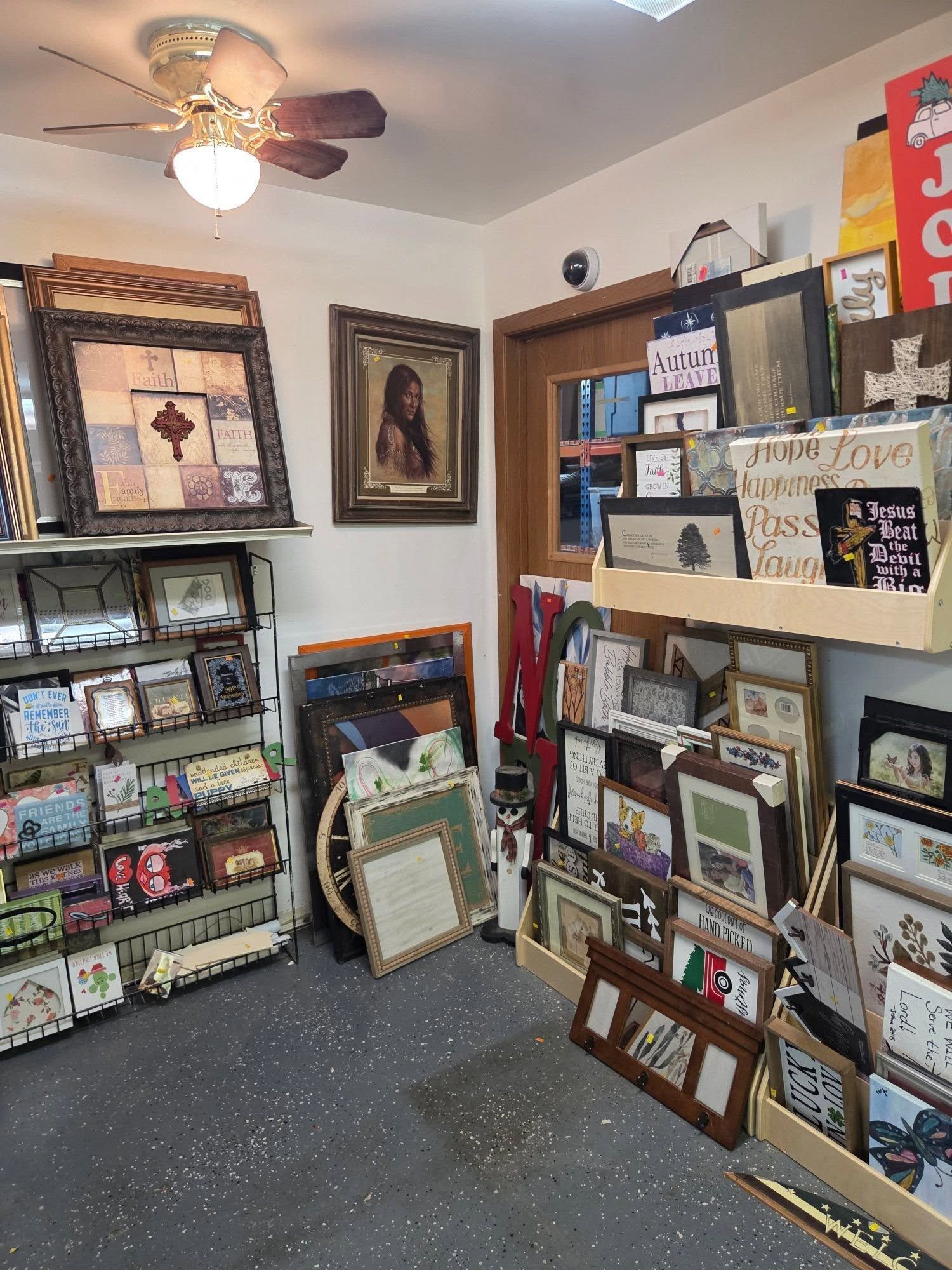 Greeting card shop display with framed art, cards, and shelves in a small room