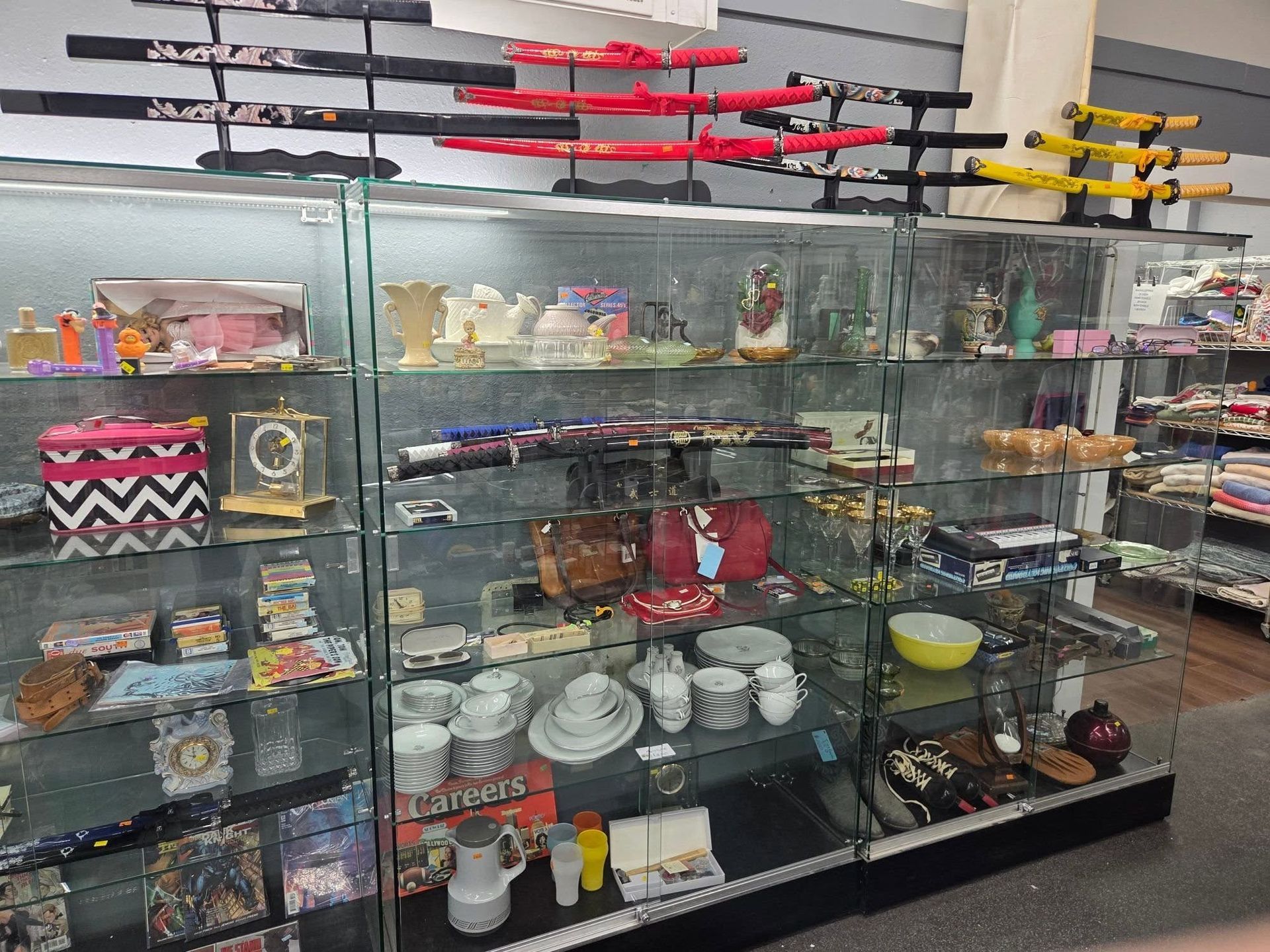 Glass display case with colorful bowls, plates, and decor items in a shop