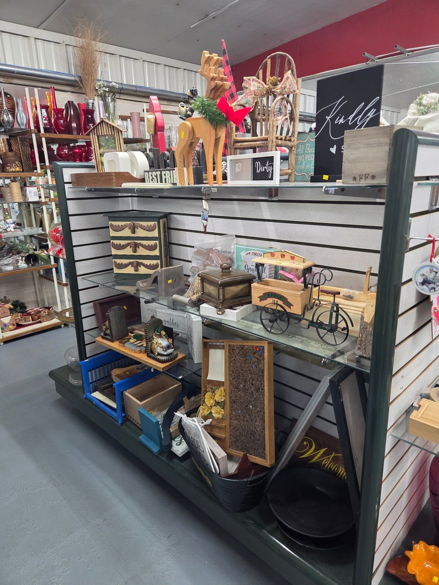 Retail display of assorted home decor and gifts on gray shelves in a shop