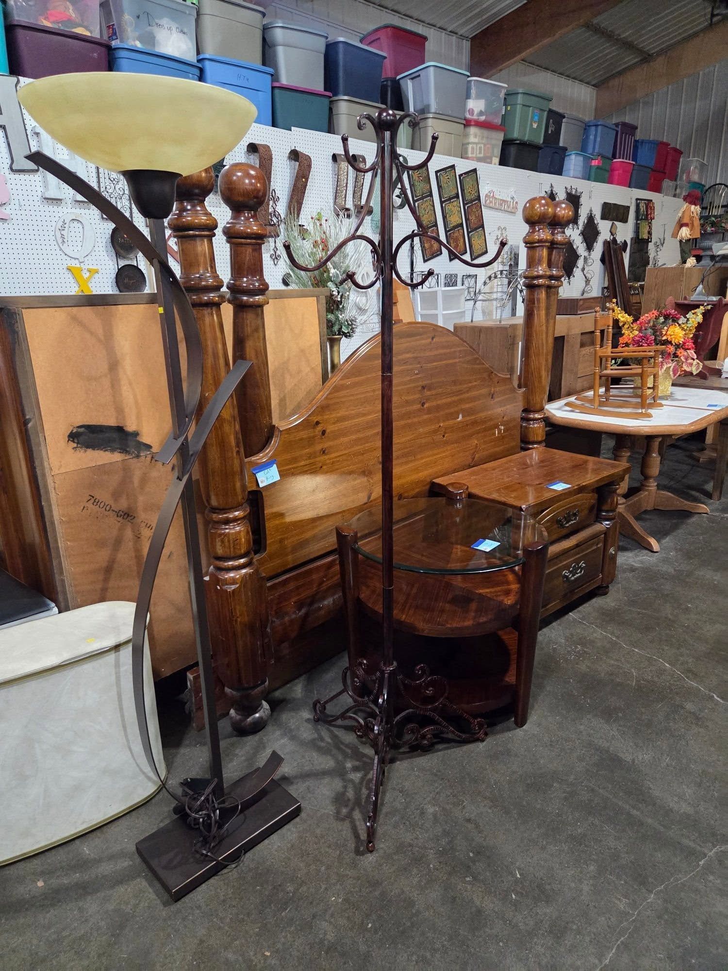 Antique wooden bench and side table displayed among vintage lamps in an indoor furniture shop