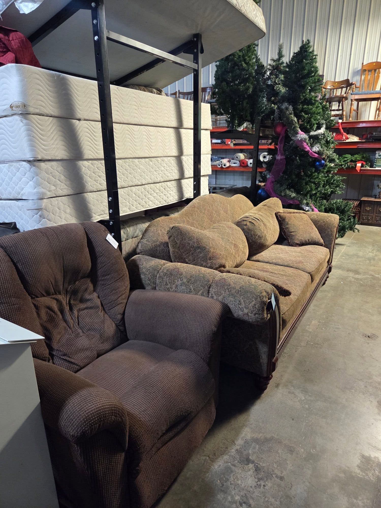Row of upholstered chairs in a warehouse aisle, with a red holiday decoration in the background