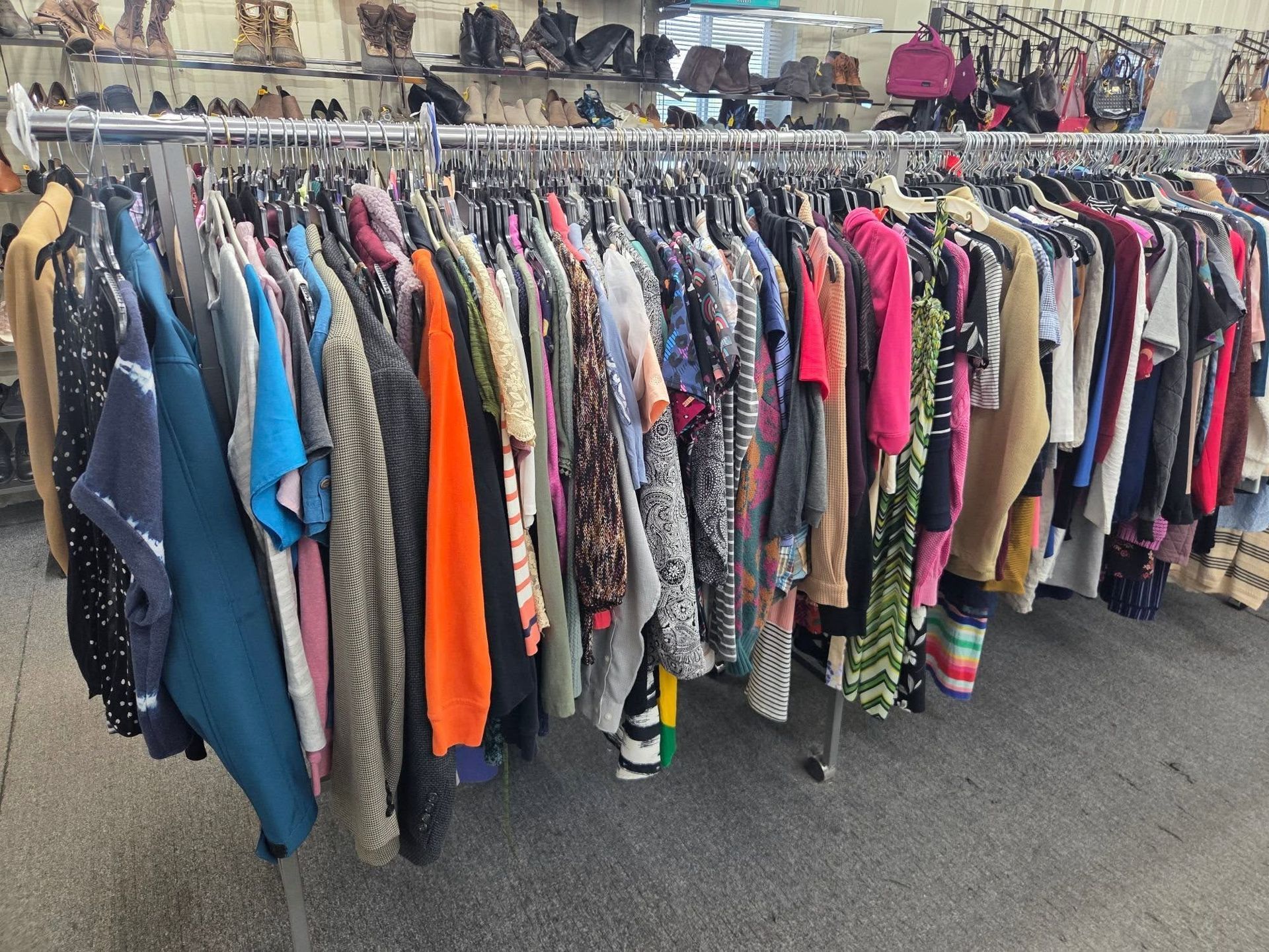 Rack of assorted colorful clothing at an outdoor flea market