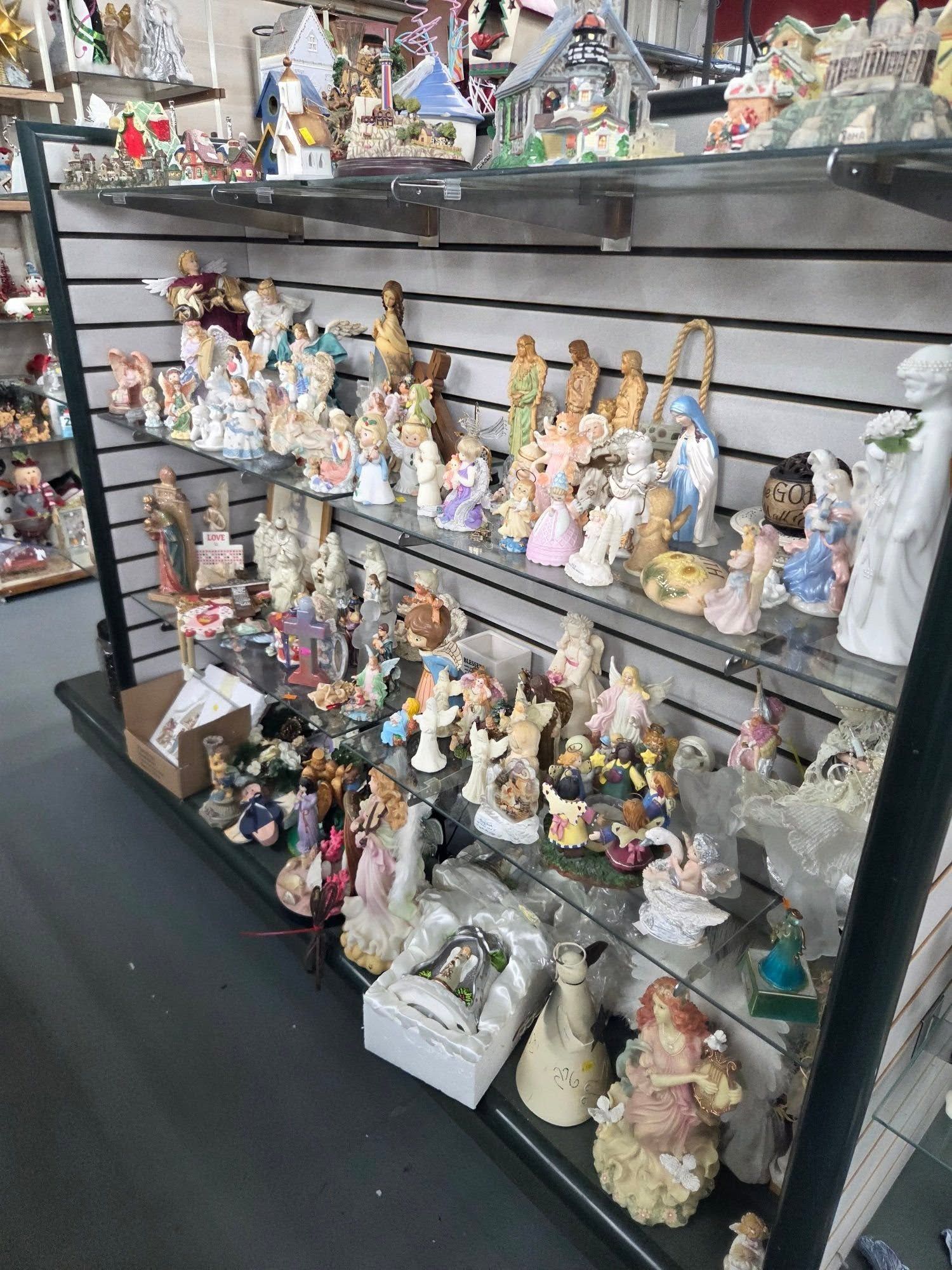 Shelves of assorted ceramic figurines and collectibles displayed in a shop.