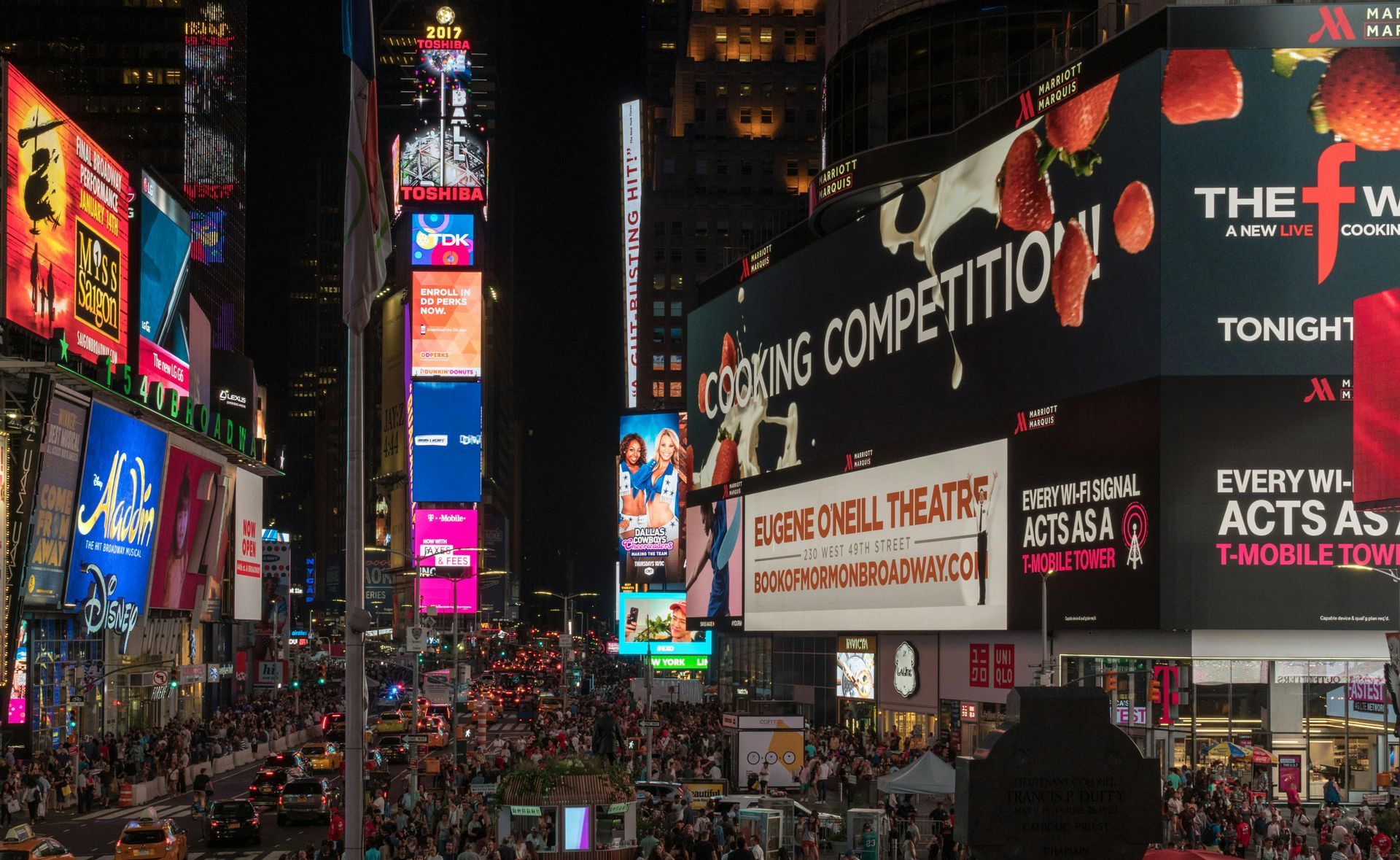 Times Square at night, bright billboards, crowded streets, colorful lights illuminate the iconic New York City location.