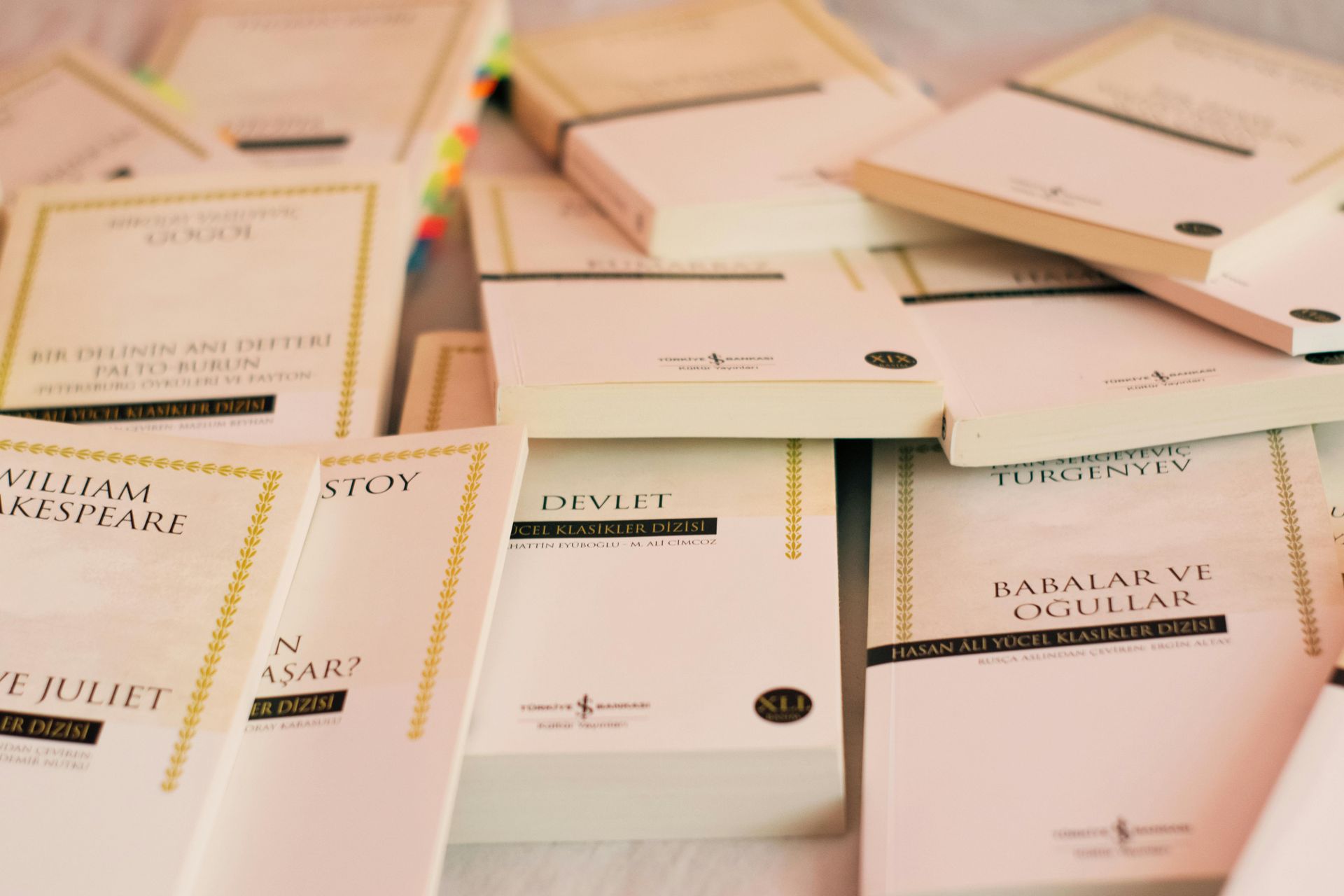 Pile of books with white covers, some titled in gold and black text.