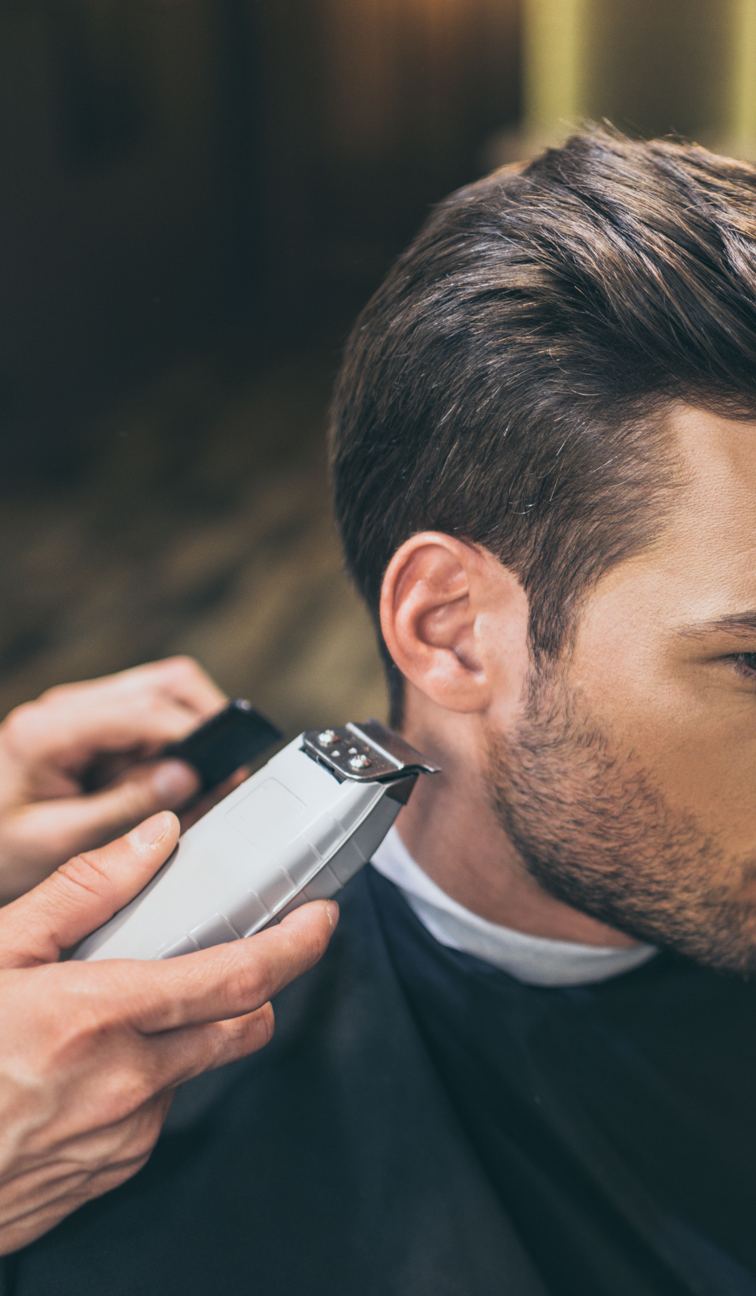 a woman is getting her hair cut by a hairdresser while holding a comb .