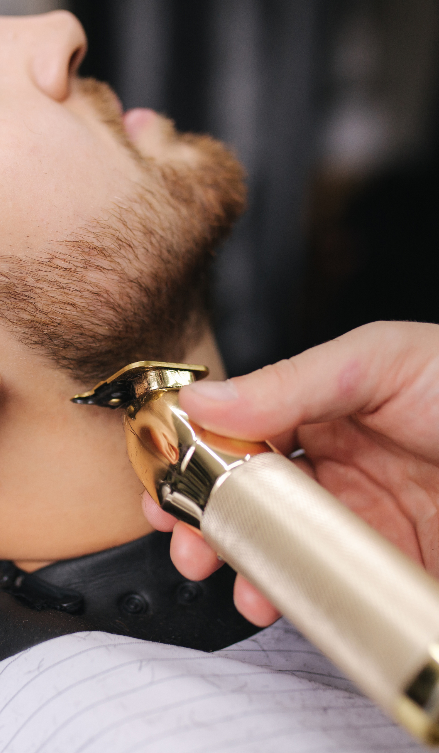 a woman is getting her hair cut by a hairdresser while holding a comb .