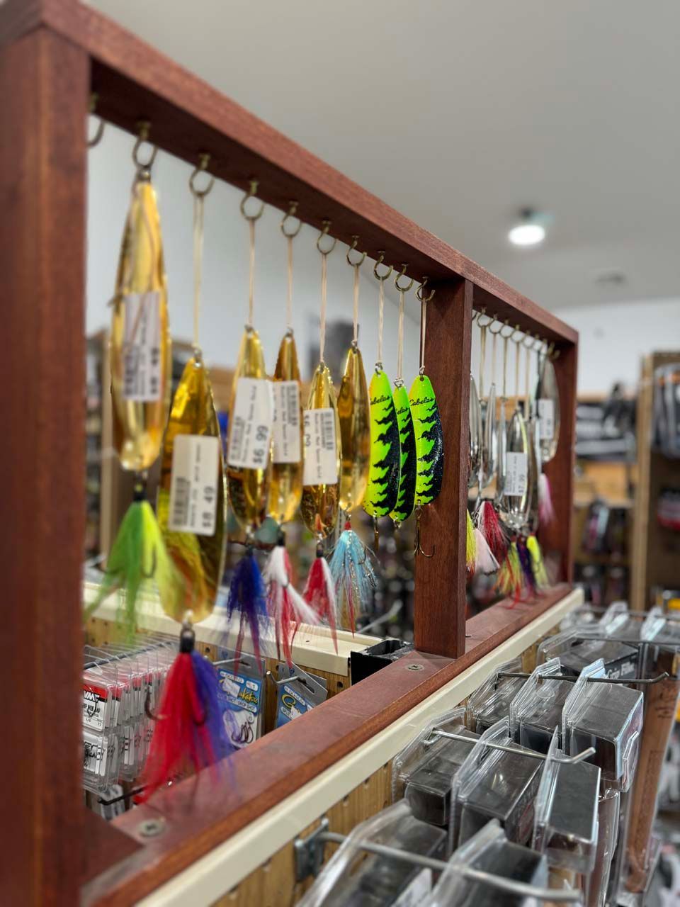 A display of fishing lures in a store with a wooden frame