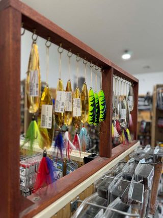 A display of fishing lures in a store with a wooden frame