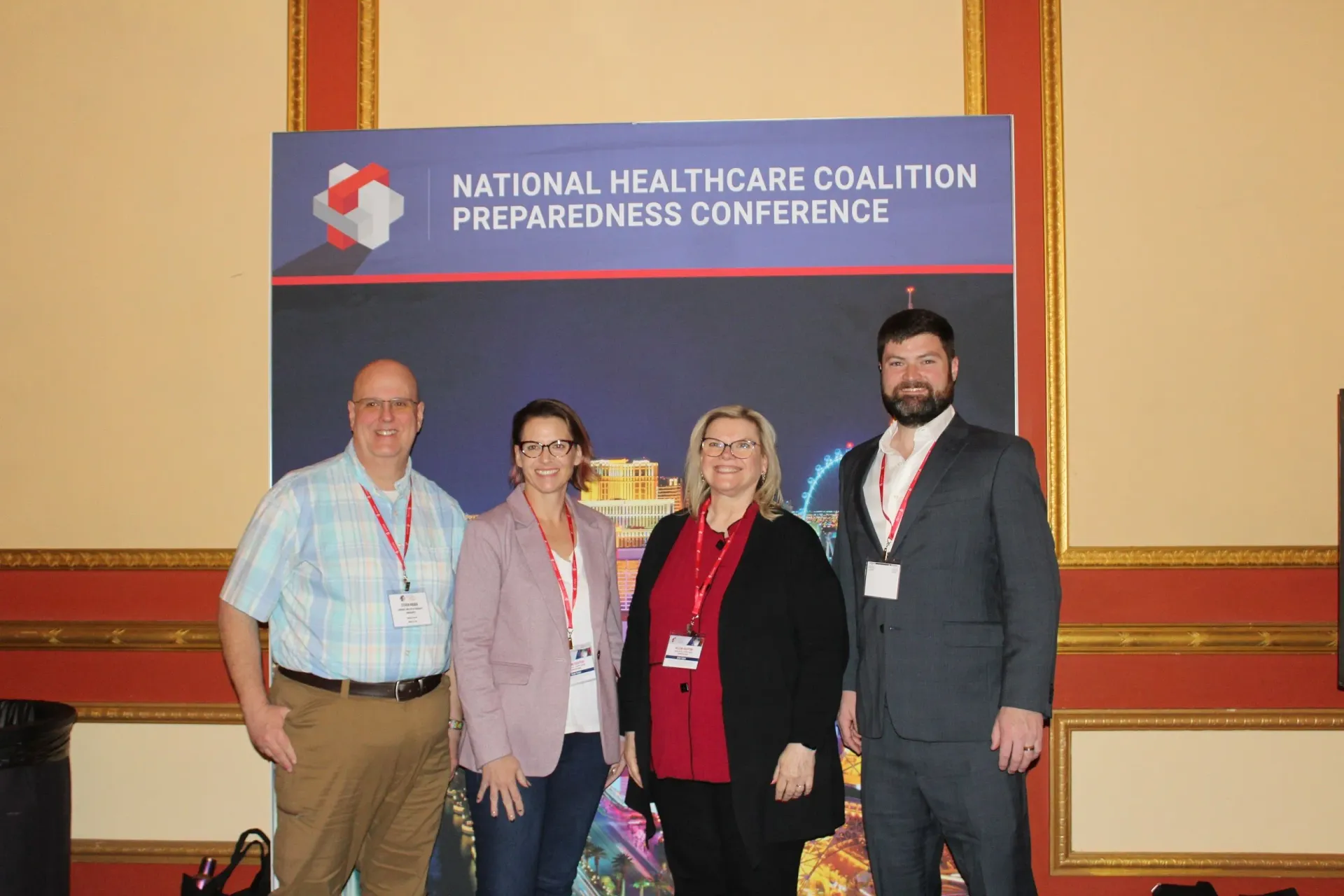a group of people standing in front of a sign that says national healthcare coalition preparedness conference .