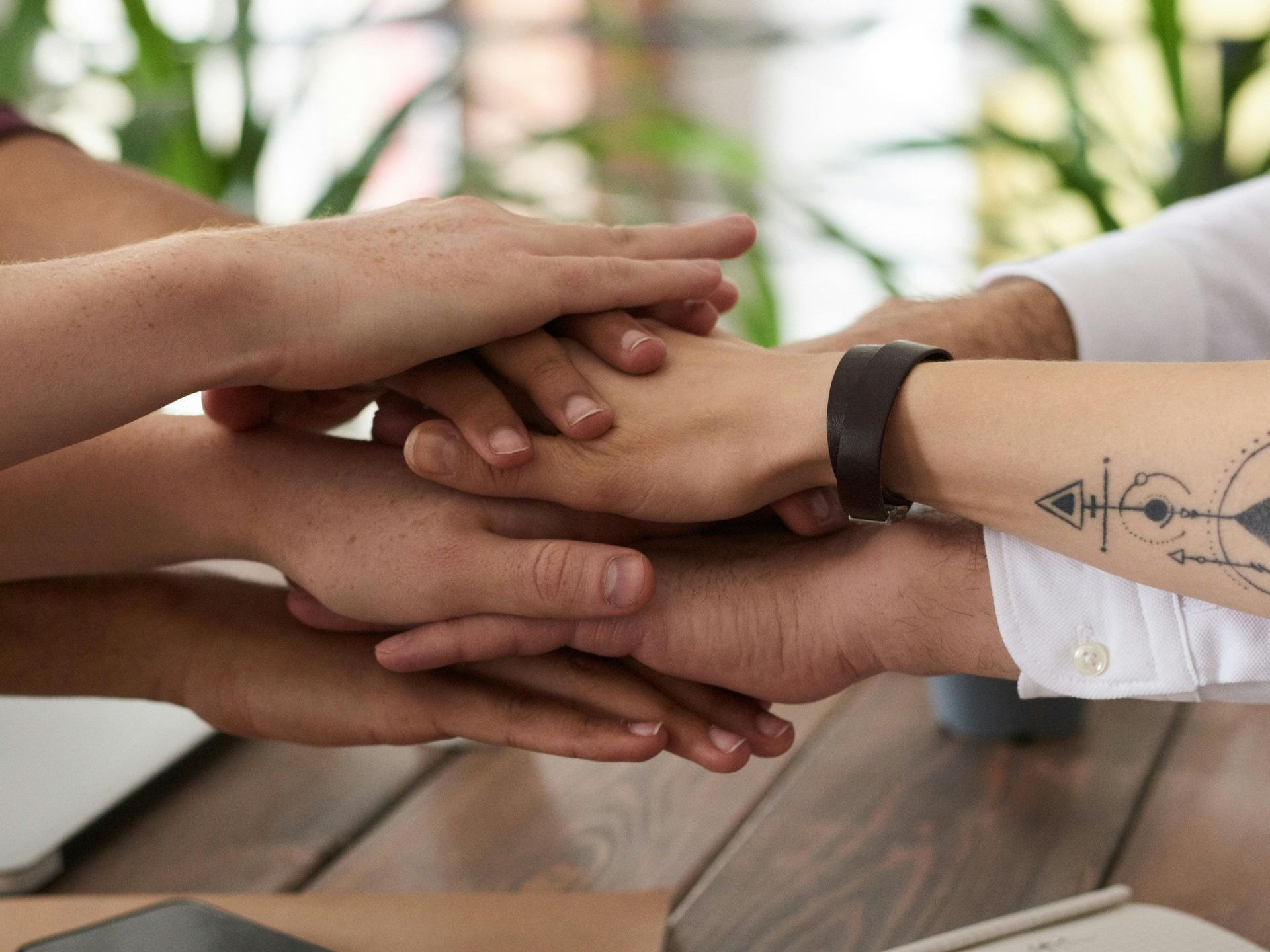 A group of people are putting their hands together.