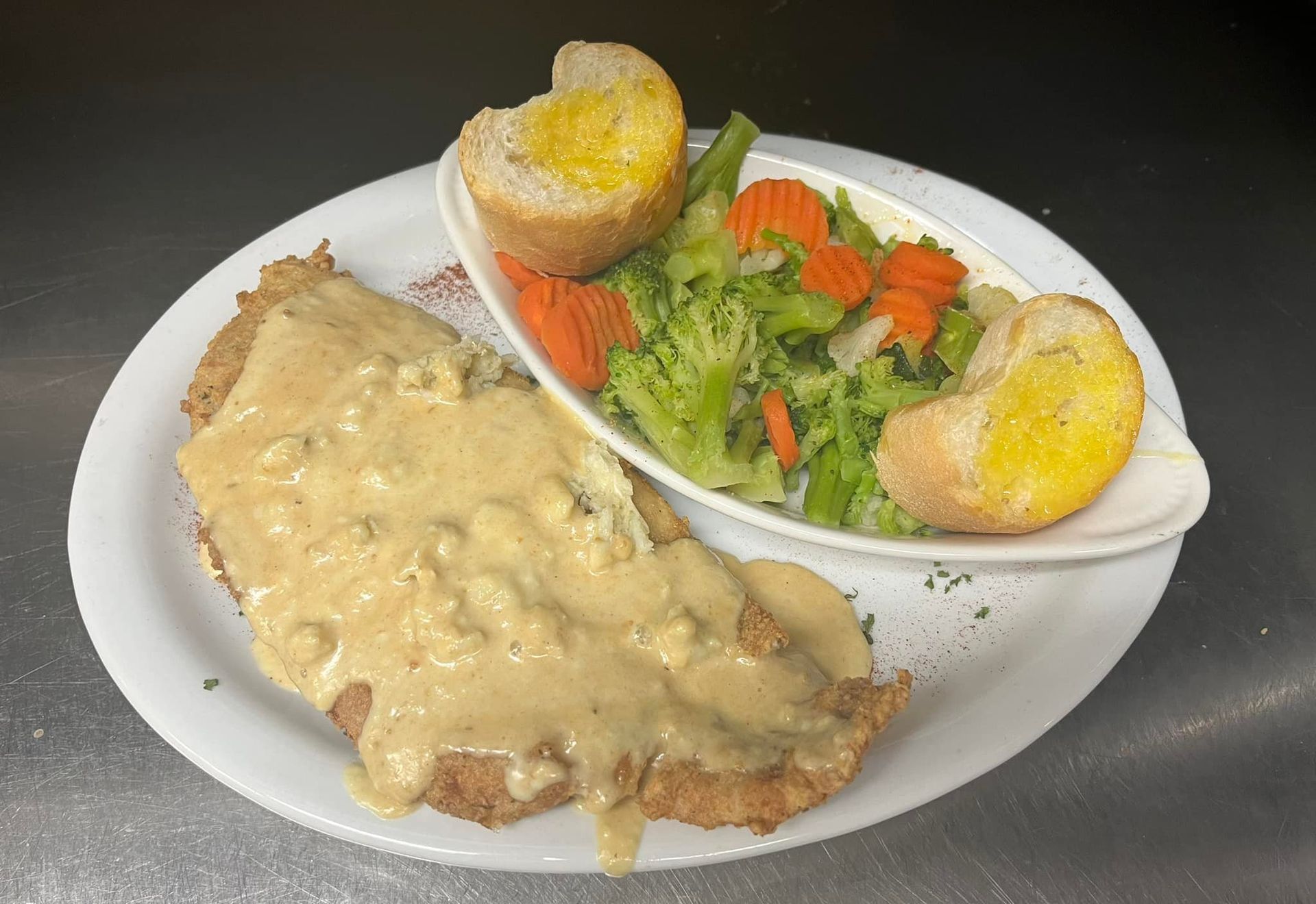 A plate of food with meat and vegetables on a table.