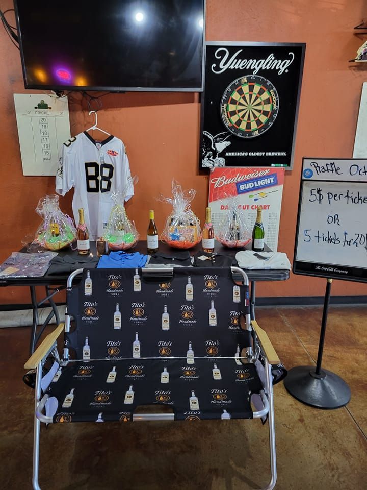 A table with a chair and a dart board in a room.