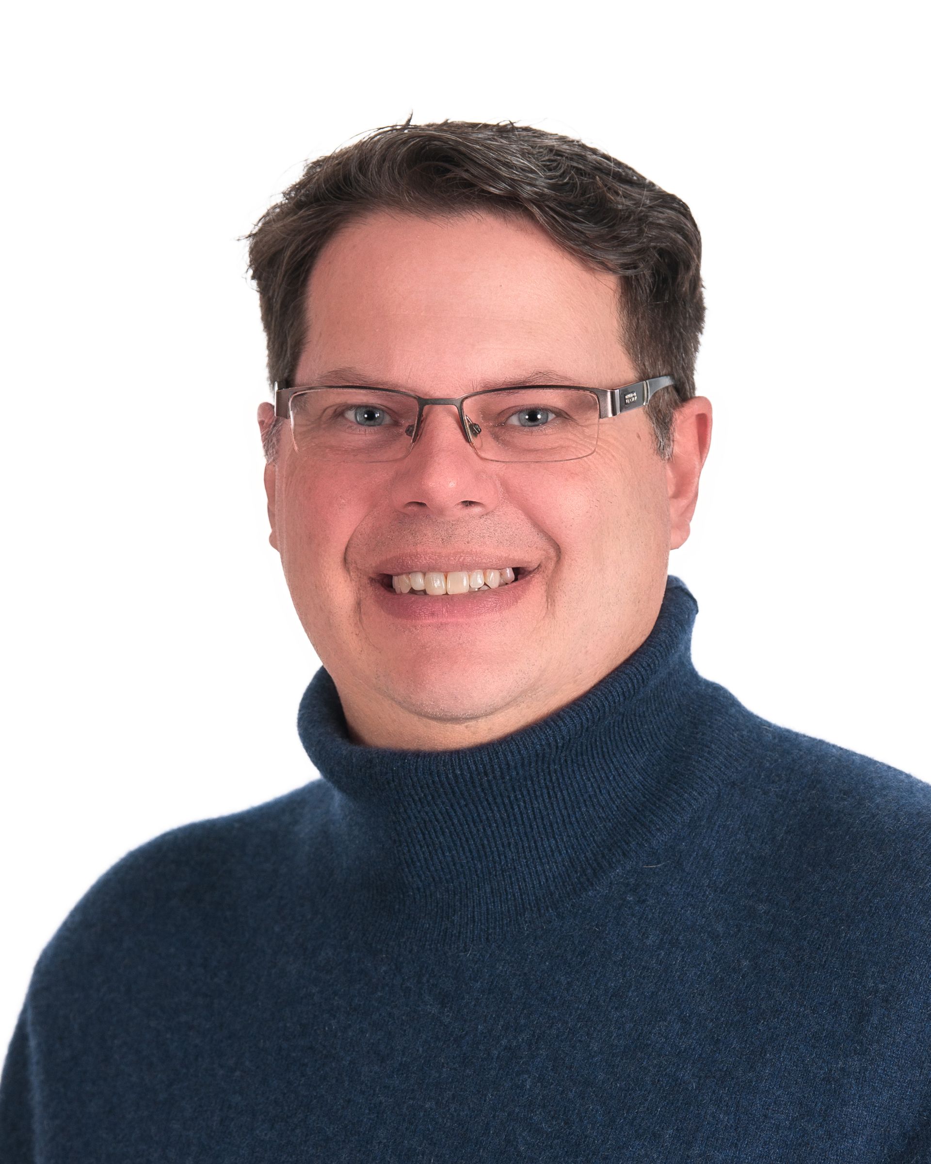 Smiling person in glasses and a dark blue sweater on a white background
