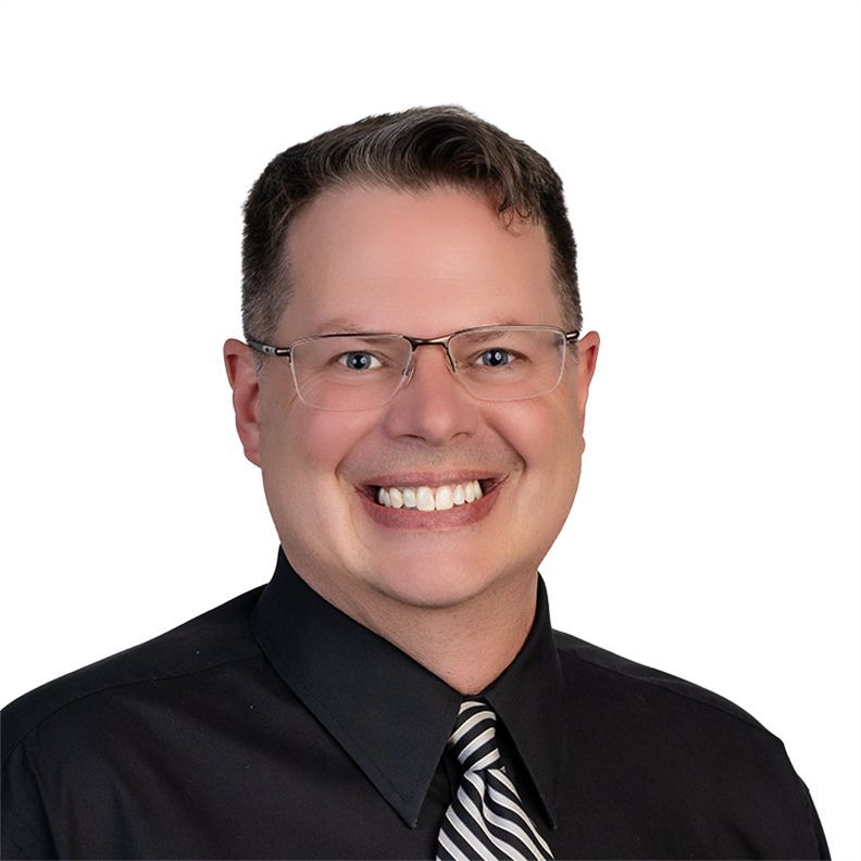 Smiling person in glasses and a dark blue sweater on a white background