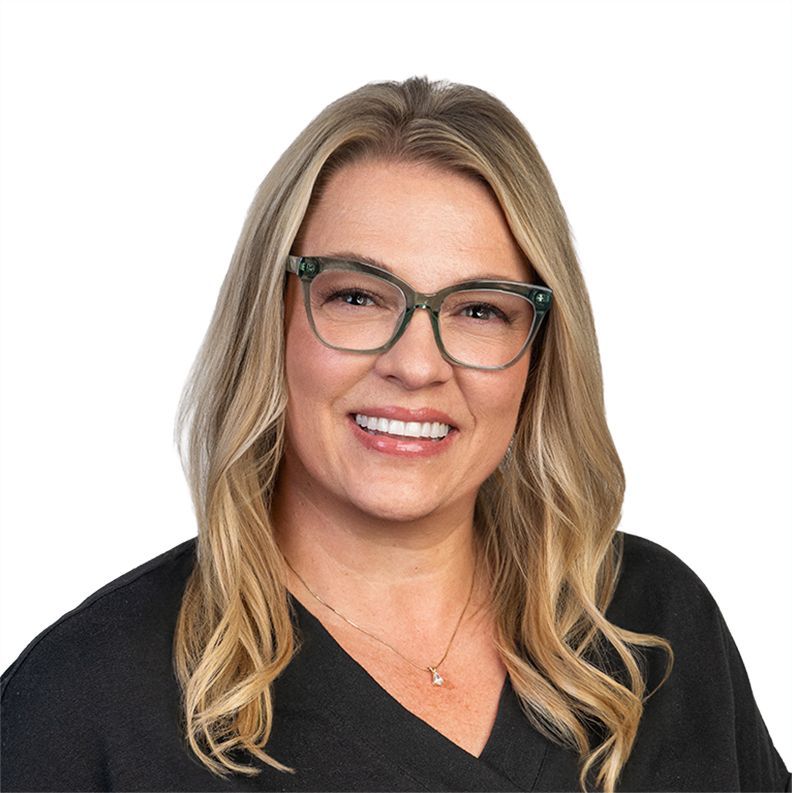 Woman with glasses smiling in a dark sweater against a white background