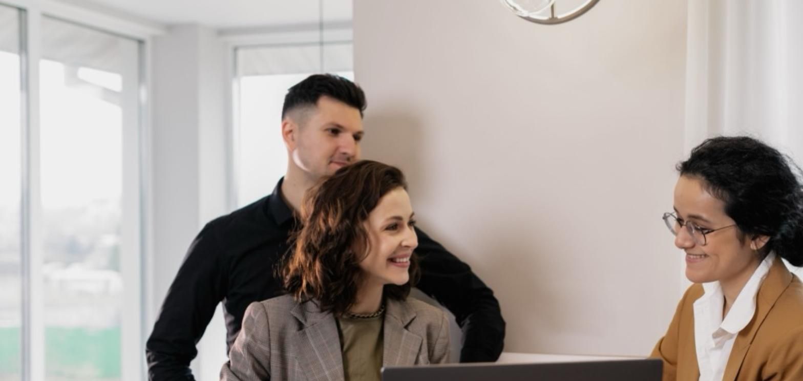 Couple meeting with a licensed insurance agent at a desk with a laptop