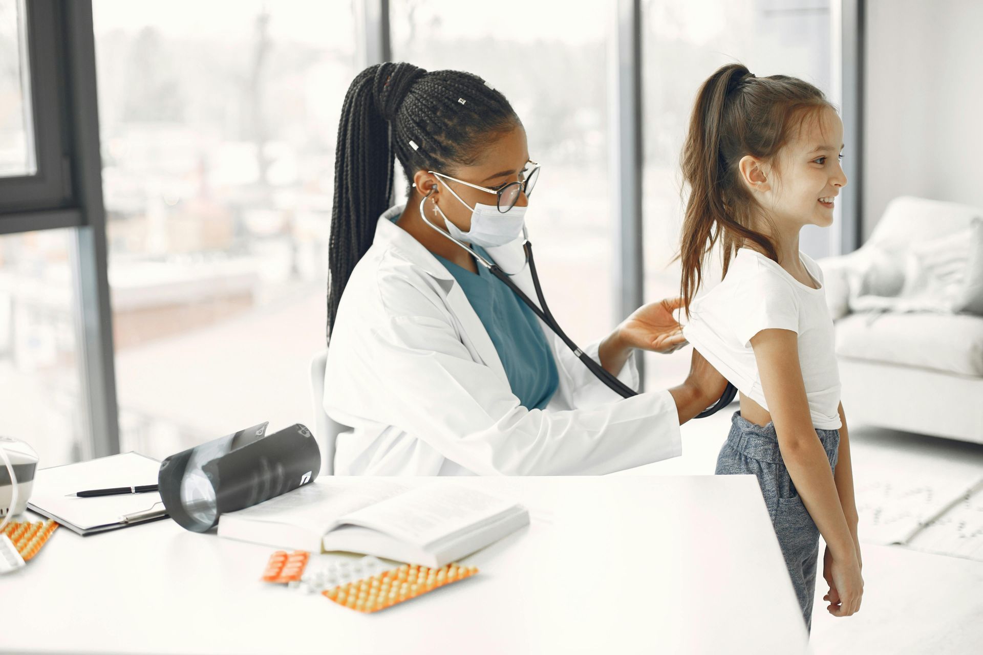 Doctor checking a child’s back during a medical exam in a bright clinic