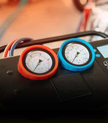 Two gauges, one red and one blue, on a black machine; hoses attached | NOR-CAL AUTOMOTIVE