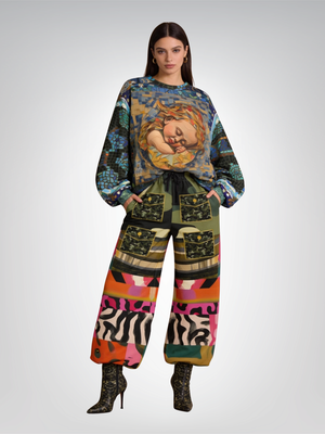 Woman in patterned sweatshirt and pants, wearing ankle boots.