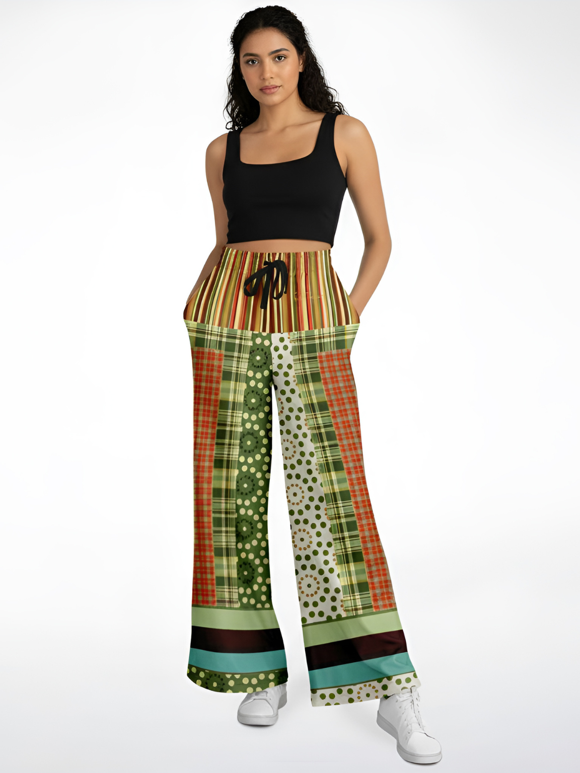 Woman wearing black crop top and patchwork print wide-leg pants with white sneakers.