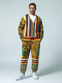 Man in colorful patterned cardigan and pants, white shirt, sneakers, hands in pockets.
