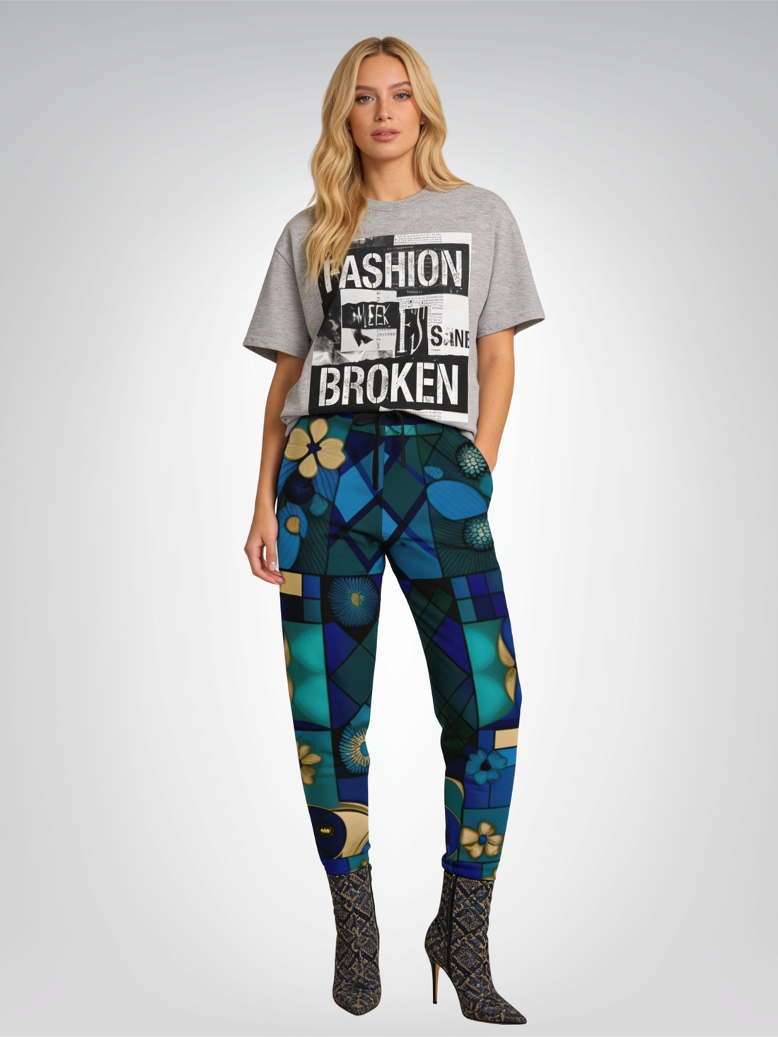Woman in grey graphic tee and patterned blue pants, black boots.