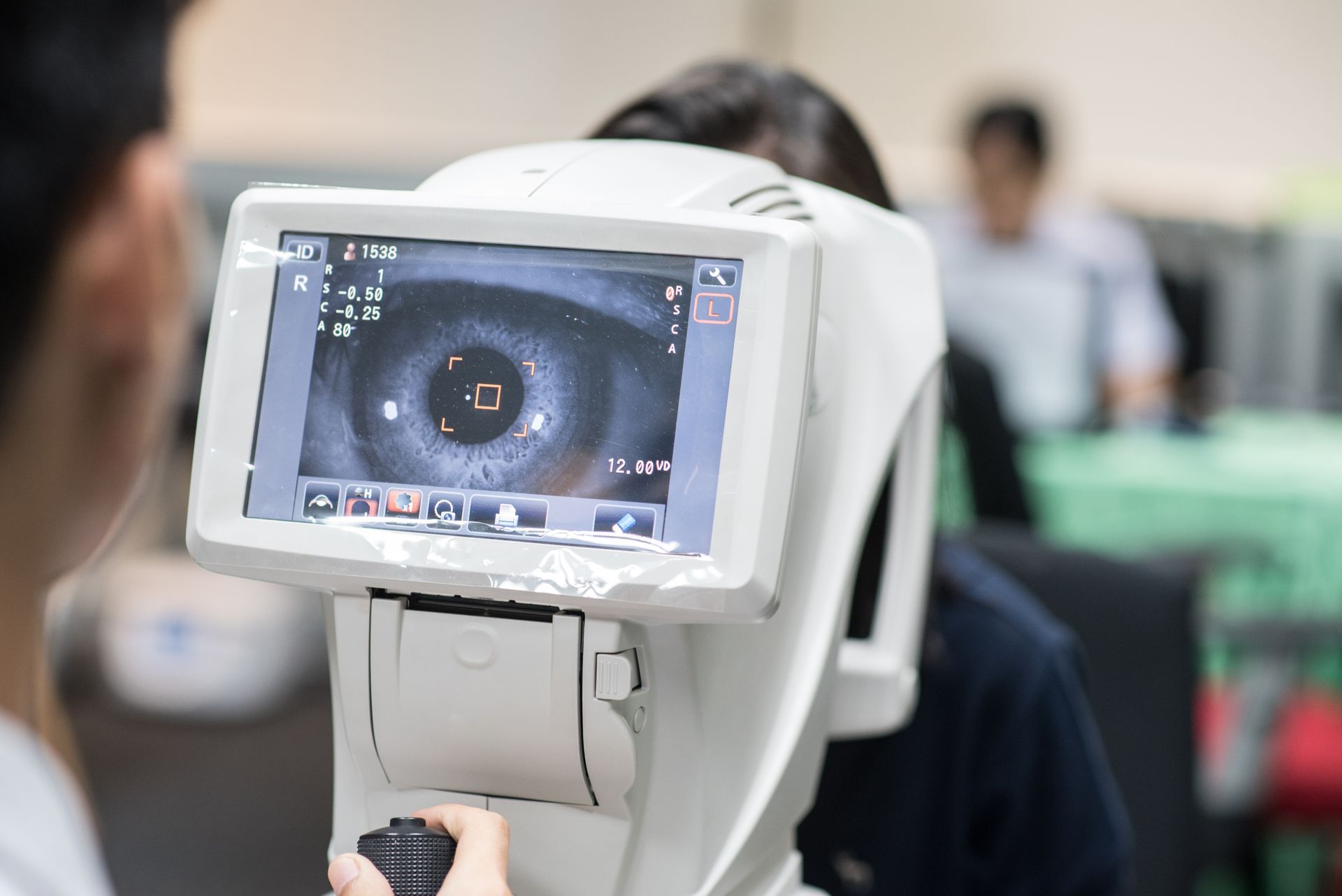 Optometrist performing an eye exam with diagnostic equipment