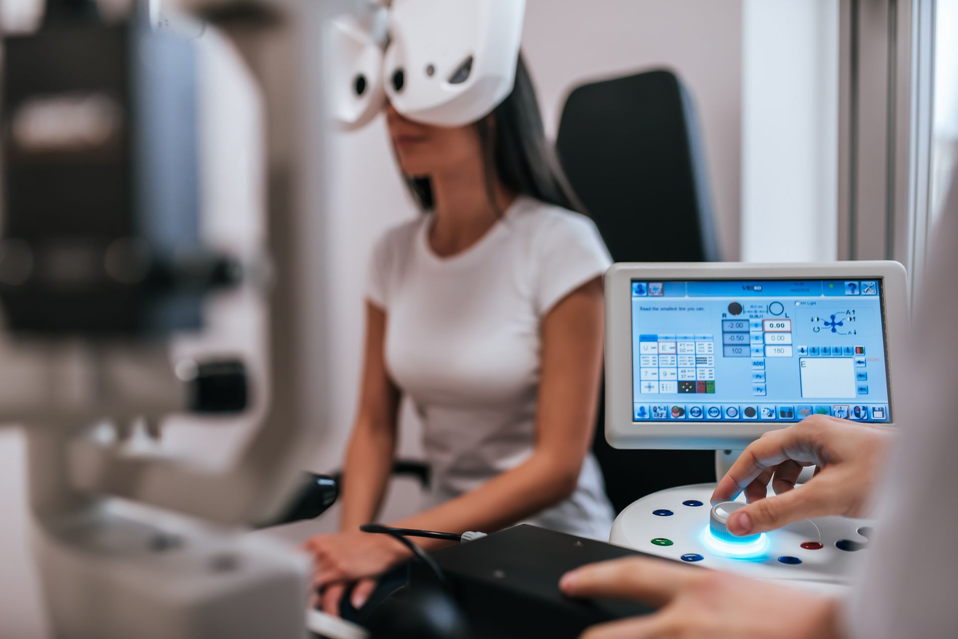 Patient undergoing eye exam with autorefractor device at optometrist clinic
