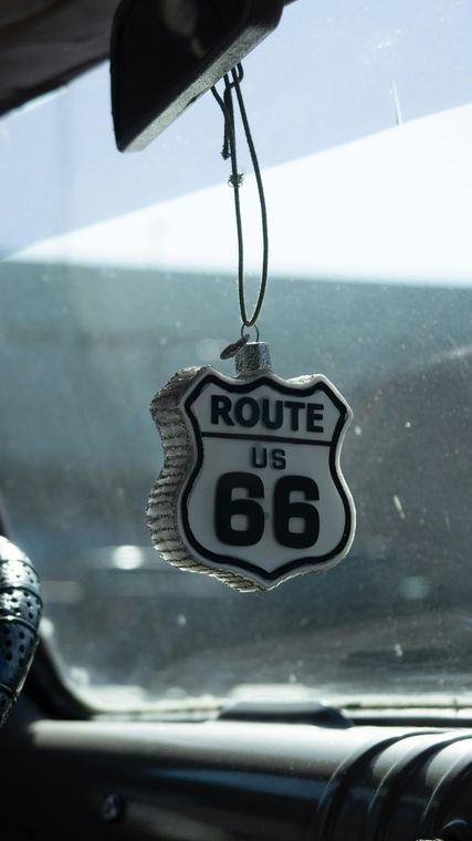 A route 66 air freshener hangs from a rear view mirror