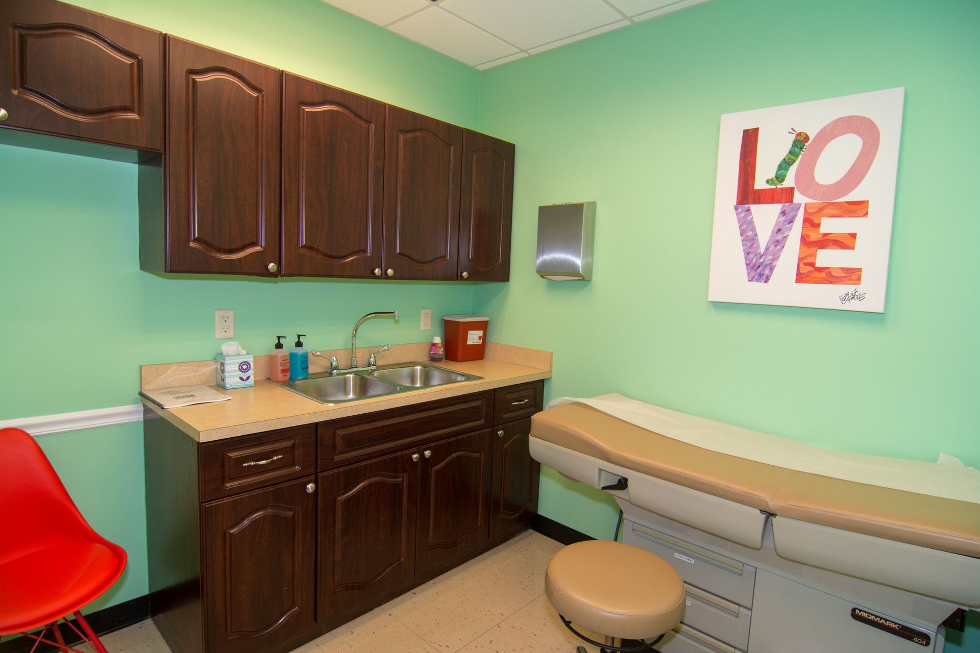 Photo inside the consultation room showing an examination bed right beside the sink