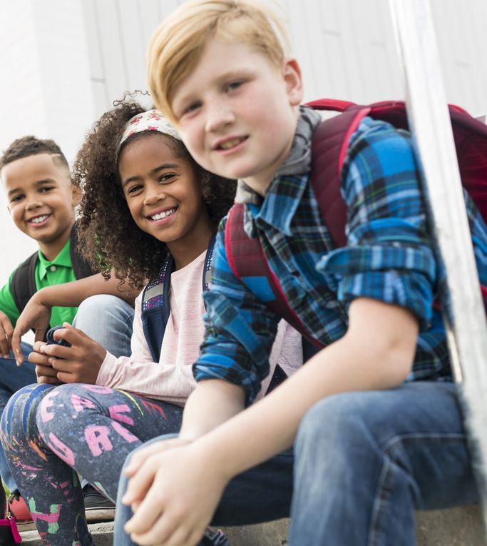 school aged kids sitting outside together