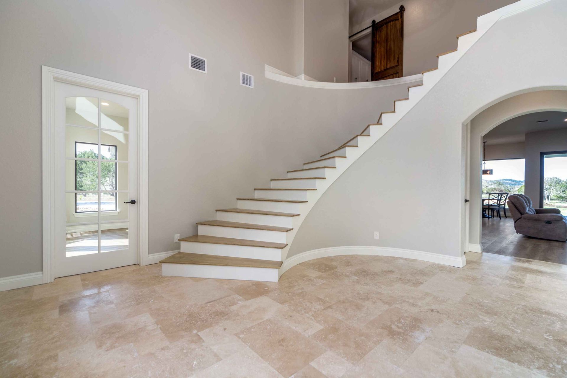 There is a curved staircase in the middle of the room.